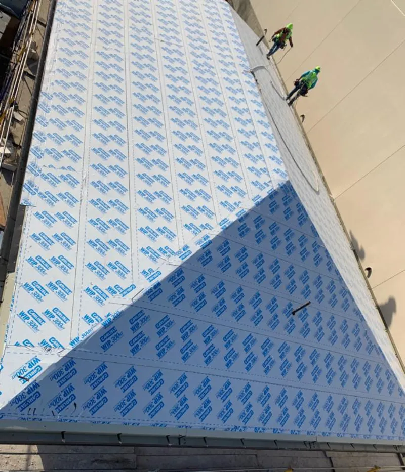 Professional roofers installing underlayment on a metal roof in Monroeville